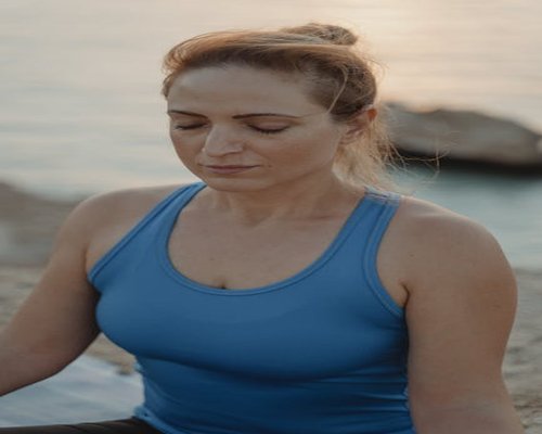person doing breathing exercises by the sea